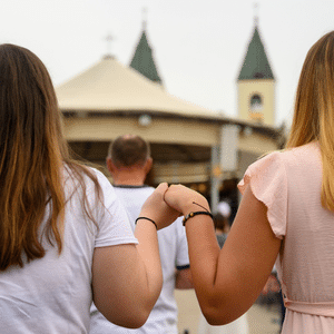 Pilgrims holding hands during Mass at St. James Church in Medjugorje