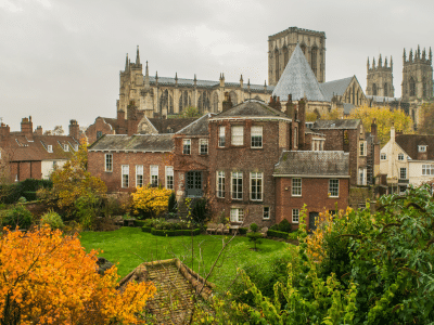 Colorful autumn gardens of british manor with view of York Minster in York England