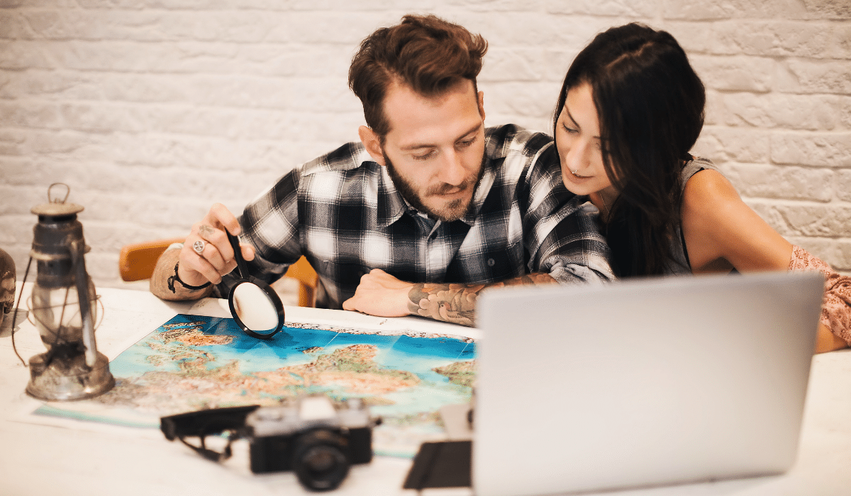 people sitting at a desk with a map and computer planning a pilgrimage