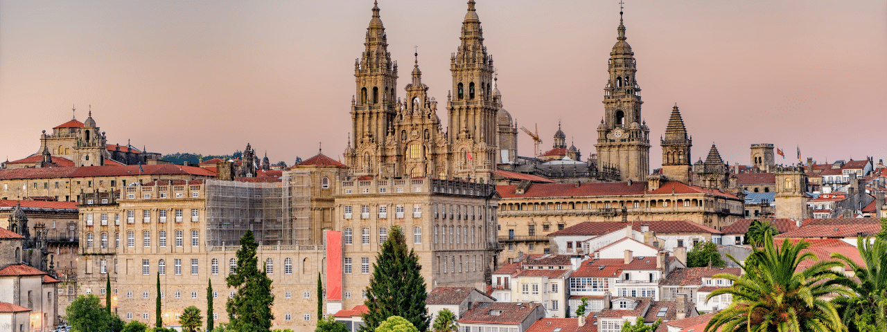 Hazy sunset on monumental Santiago de Compostela Cathedral and cityscape.